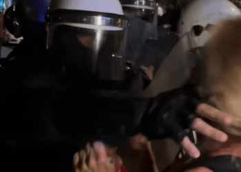 Polici godet  një grua para zyrës së SNS-së në Vraçar, skena brutale gjatë gjithë natës në të gjithë Serbinë