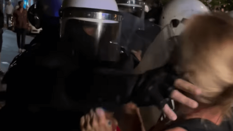 Polici godet një grua para zyrës së SNS-së në Vraçar, skena brutale gjatë gjithë natës në të gjithë Serbinë